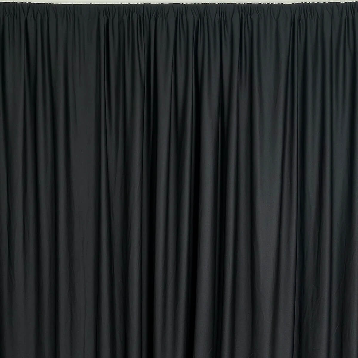 Black shiny event drape with gathered pleats hanging from a rod